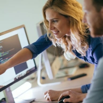 Woman pointing at monitor and smiling