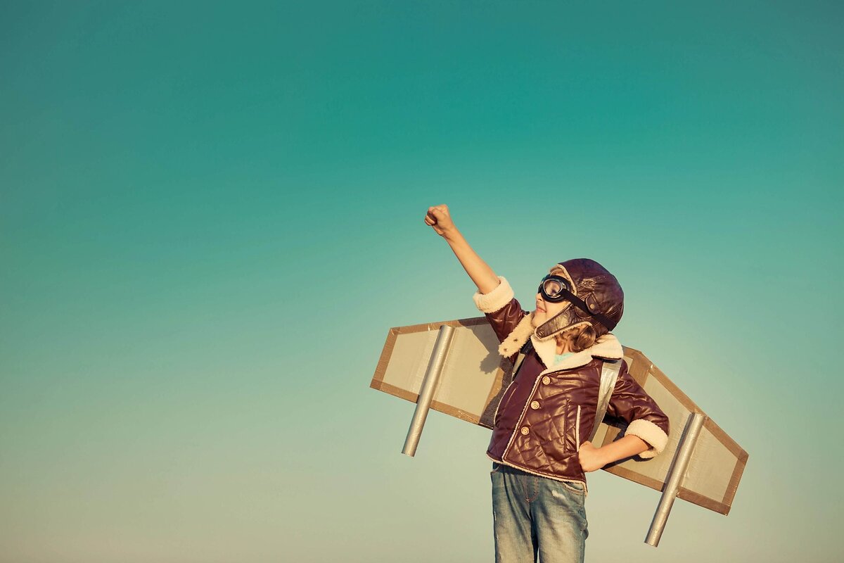 Child in aviator costume with cardboard wings