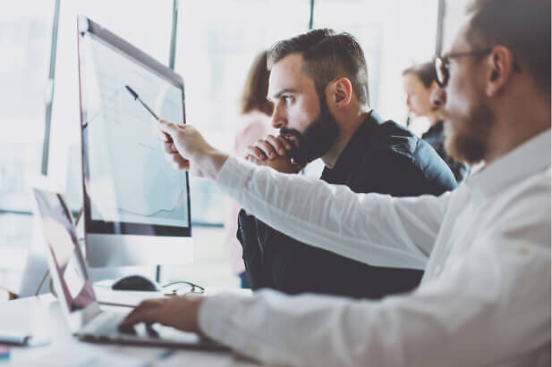 Man pointing with pen at monitor