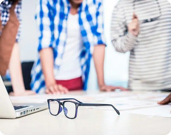Team working focussing on glasses on desk