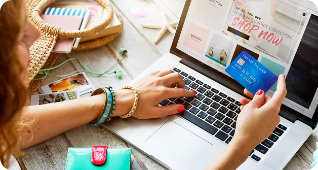Woman looking at her credit card while visiting a website